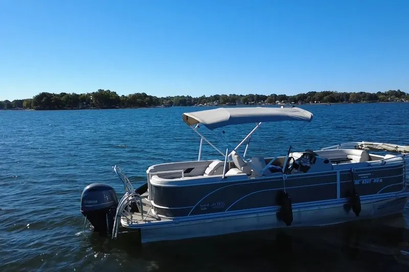 Slide: The Image of 2023 G3 Select 22RC pontoon boat on a serene lake under clear blue skies. - 60