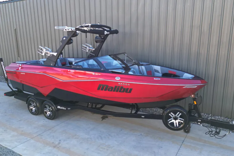 The Image of 2023 Malibu Wakesetter 25 LSV boat in vibrant red on trailer. - 1