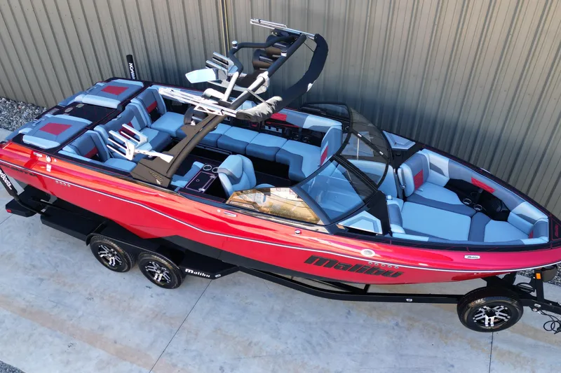 Slide: The Image of 2023 Malibu Wakesetter 25 LSV boat, red exterior, spacious seating, parked on trailer. - 4