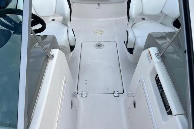 Slide: The Image of 2016 Chaparral 21 H2O Sport boat interior with white seating and central storage. - 11