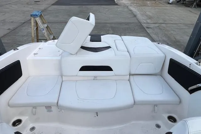 Slide: The Image of 2016 Chaparral 21 H2O Sport boat interior with white seating and storage compartments. - 16