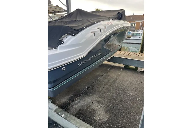 Slide: The Image of 2016 Chaparral 21 H2O Sport boat covered and docked at a marina. - 2