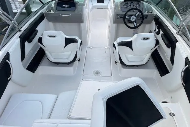 Slide: The Image of 2016 Chaparral 21 H2O Sport boat interior with white seating and steering console. - 6