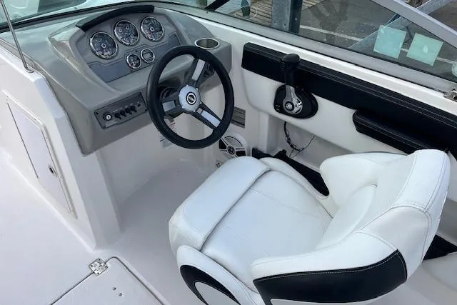 Slide: The Image of 2016 Chaparral 21 H2O Sport boat cockpit with steering wheel and white captain's chair. - 8