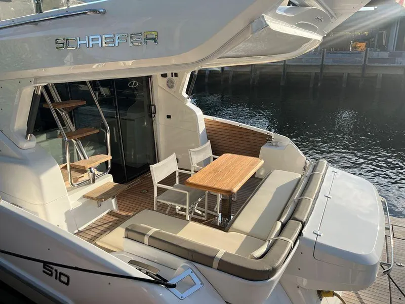 Slide: The Image of Luxurious 2019 Schaefer 510 yacht with elegant outdoor seating and dining area by the water. - 16