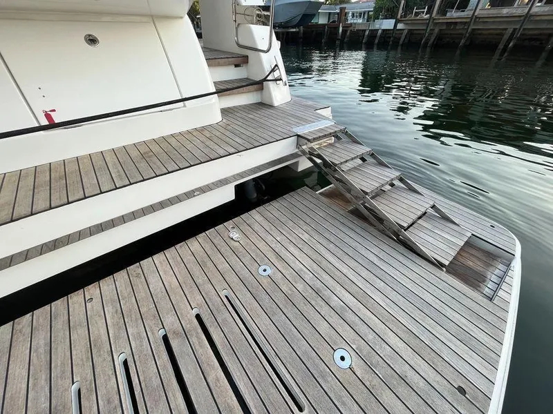 Slide: The Image of Schaefer 510 yacht's wooden deck and steps, 2019 model, docked by the water. - 28