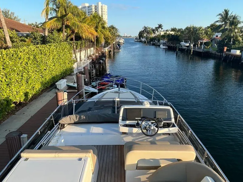 Slide: The Image of Luxury Schaefer 510 yacht cruising a scenic canal, surrounded by palm trees and waterfront homes. - 44