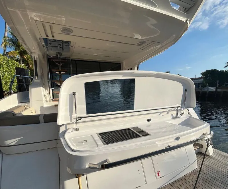 Slide: The Image of Schaefer 510 yacht's outdoor kitchen area with grill, 2019 model, docked by water. - 9