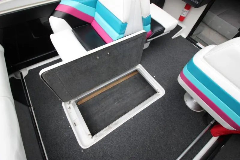 Slide: The Image of 1989 Formula 223 SS boat interior with open storage compartment and colorful seating. - 22