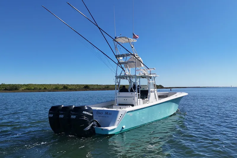 Slide: The Image of 2013 SeaVee 39B Center Console boat on calm water, equipped with triple Mercury engines. - 13