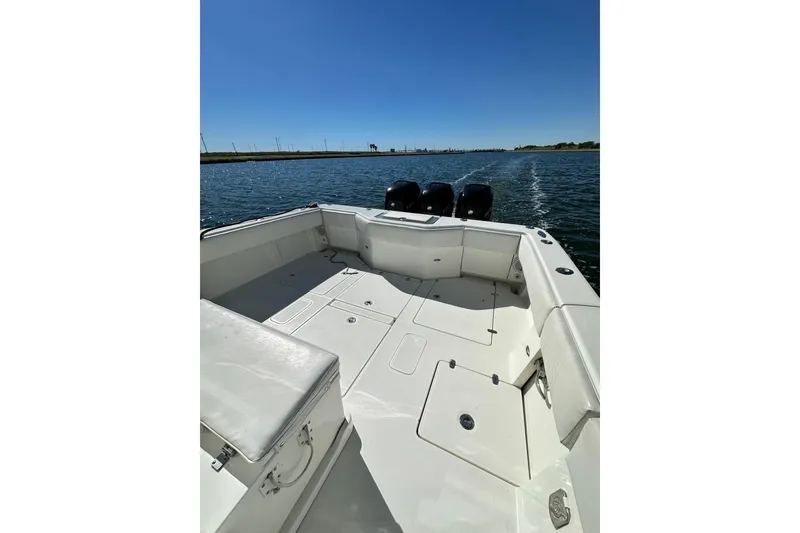 Slide: The Image of 2013 SeaVee 39B Center Console boat on open water, featuring spacious deck and triple engines. - 22