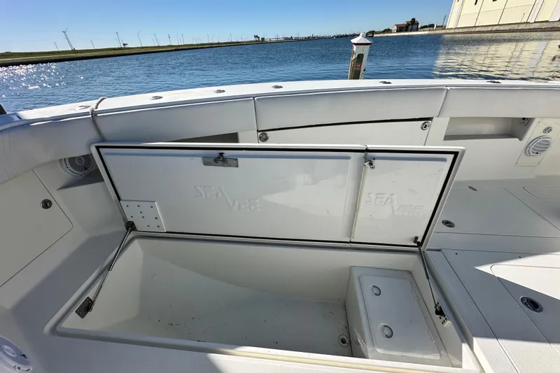 Slide: The Image of 2013 SeaVee 39B Center Console boat with open storage compartment by the water. - 33