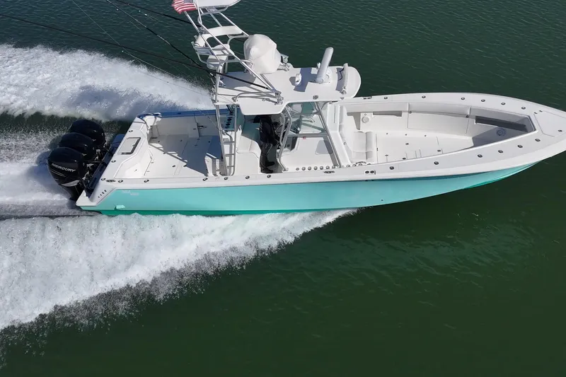 Slide: The Image of 2013 SeaVee 39B Center Console boat cruising on water with triple outboard engines. - 6