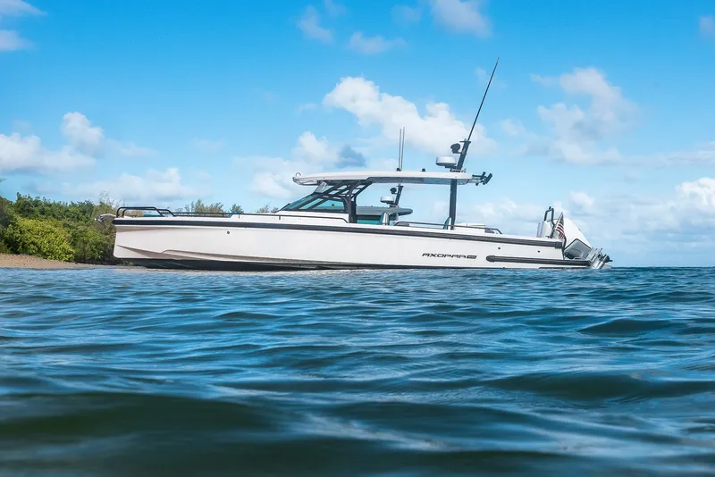 Slide: The Image of 2021 Axopar Suntop Brabus Trim boat on calm water under blue sky. - 4