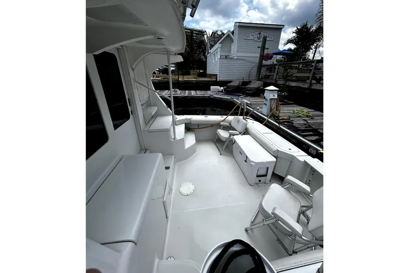 Slide: The Image of 2001 Luhrs 34 Convertible boat deck with seating and dock view. - 10