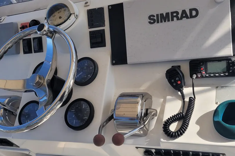 Slide: The Image of 2001 Luhrs 34 Convertible boat dashboard with steering wheel and Simrad navigation system. - 27