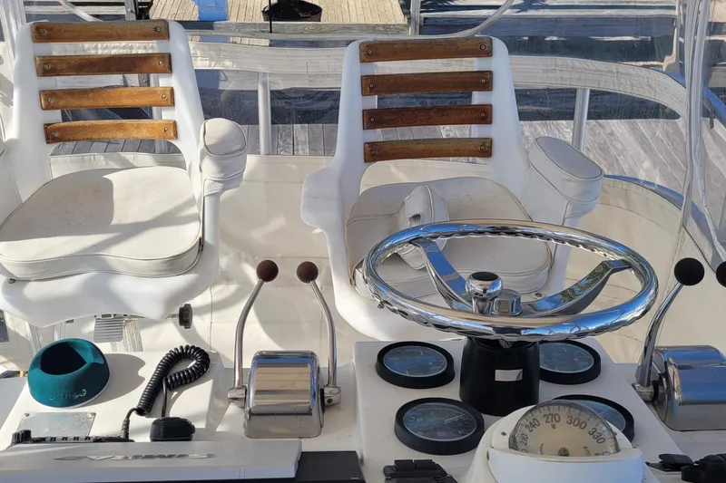 Slide: The Image of 2001 Luhrs 34 Convertible helm with steering wheel, gauges, and dual captain chairs. - 28