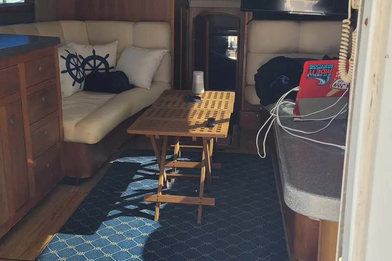 Slide: The Image of Interior of 2001 Luhrs 34 Convertible yacht with cozy seating and wooden table. - 33