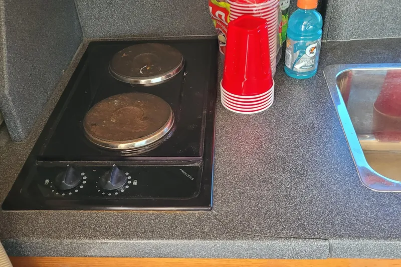 Slide: The Image of Compact kitchen area in a 2001 Luhrs 34 Convertible boat with stove and sink. - 38