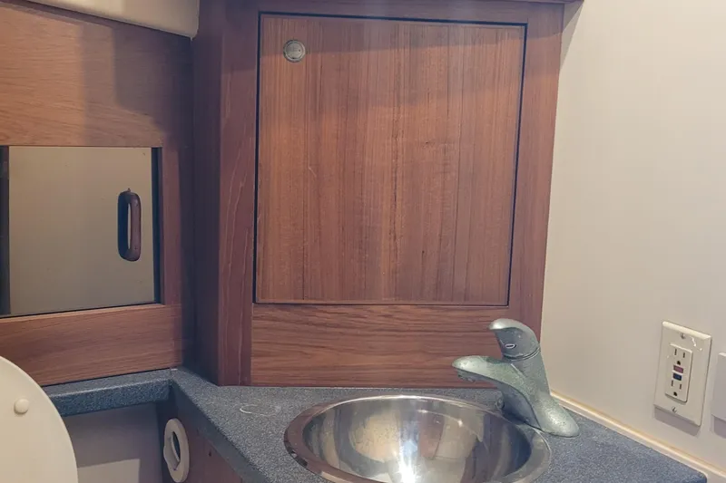 Slide: The Image of 2001 Luhrs 34 Convertible bathroom sink with wooden cabinet and modern faucet. - 45