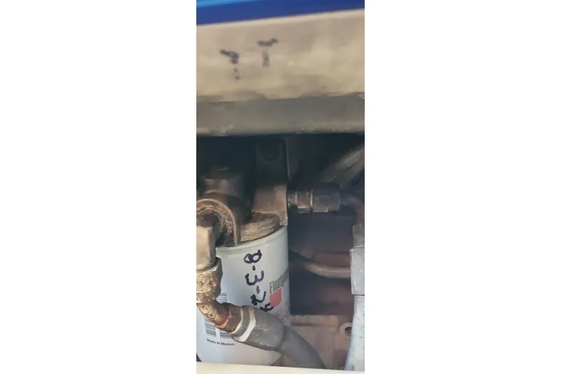 Slide: The Image of Engine component of 2001 Luhrs 34 Convertible boat, featuring a filter and hoses. - 52