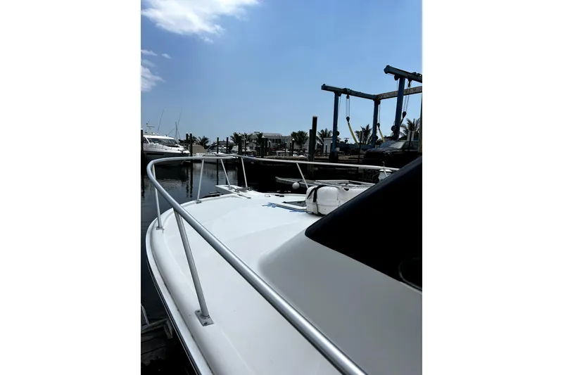 Slide: The Image of 2001 Luhrs 34 Convertible boat docked at marina under clear blue sky. - 6