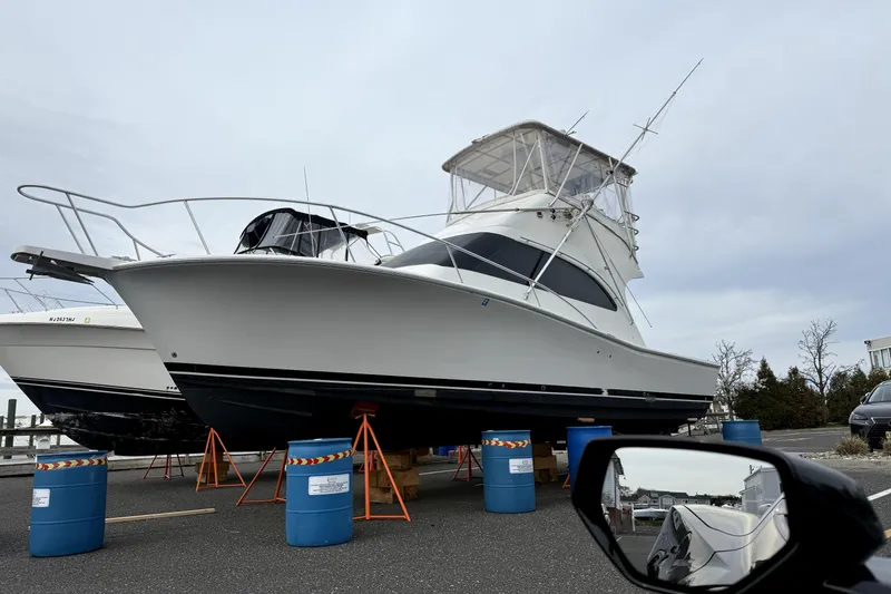 Slide: The Image of 2001 Luhrs 34 Convertible boat on stands in a marina parking lot. - 8