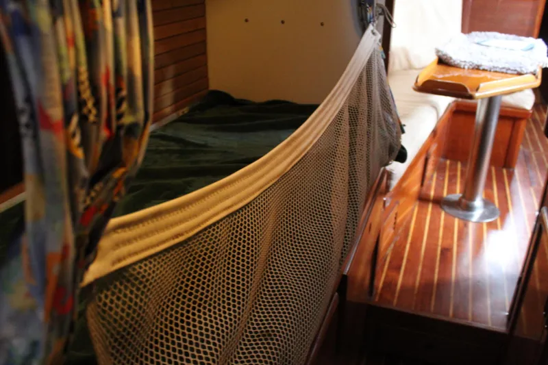 Slide: The Image of Interior of 1979 Spencer Yachts 53, featuring wooden flooring and cozy sleeping area. - 24