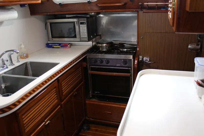 Slide: The Image of 1979 Spencer Yachts 53 kitchen with stove, microwave, and sink. - 27