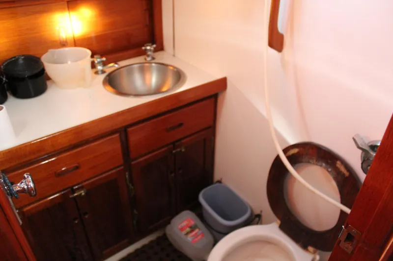 Slide: The Image of 1979 Spencer Yachts 53 bathroom with wooden cabinets, sink, and toilet. - 36