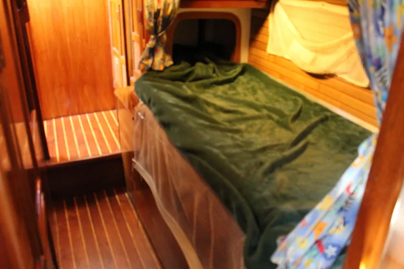 Slide: The Image of Cozy cabin interior of 1979 Spencer Yachts 53 with wooden flooring and green bedding. - 40