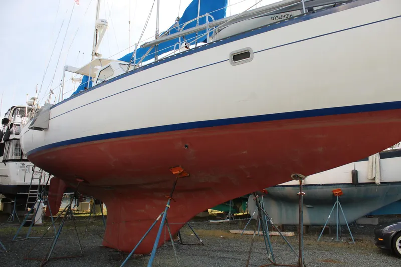 Slide: The Image of 1979 Spencer Yachts 53 sailboat on stands, showcasing red hull and blue trim. - 64