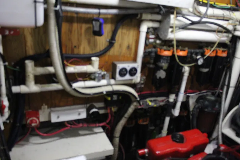 Slide: The Image of Engine room of a 1979 Spencer Yachts 53, featuring pipes and mechanical components. - 43