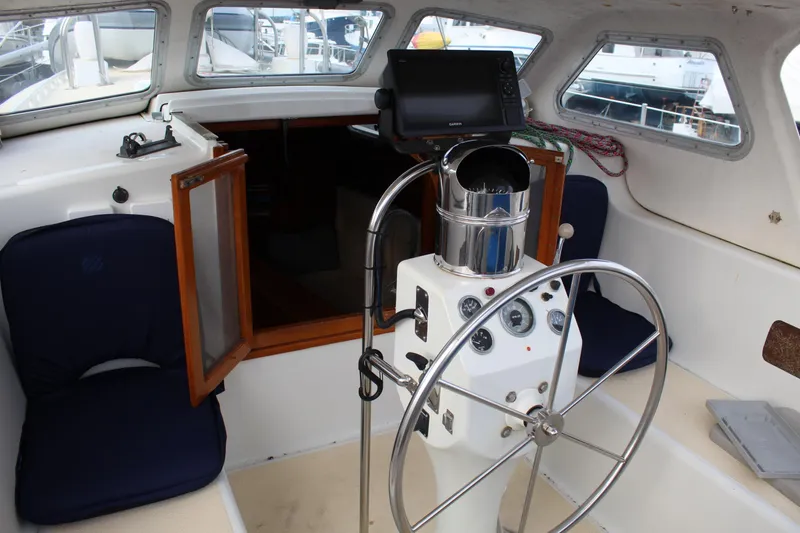 Slide: The Image of Helm of 1979 Spencer Yachts 53, featuring steering wheel and navigation equipment. - 50