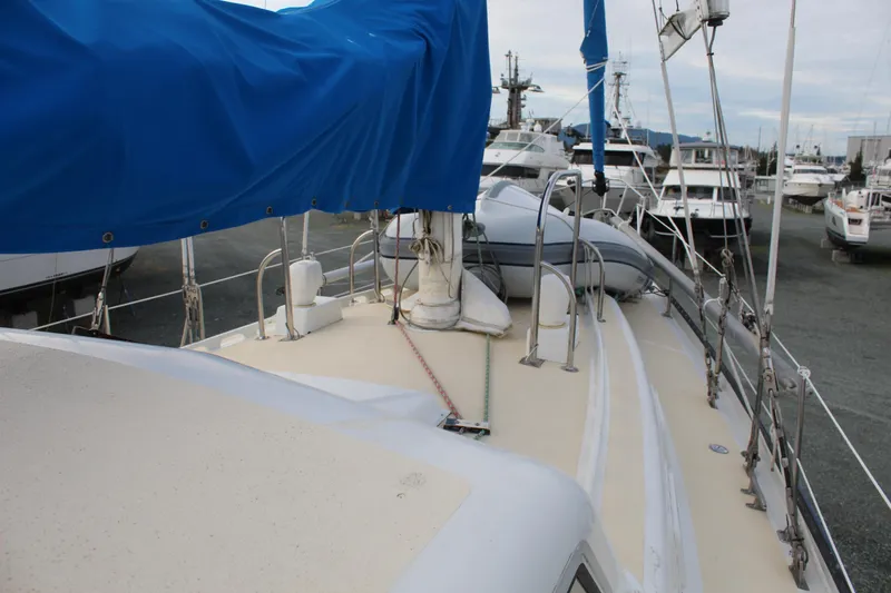 Slide: The Image of 1979 Spencer Yachts 53 sailboat deck with blue cover in marina. - 54