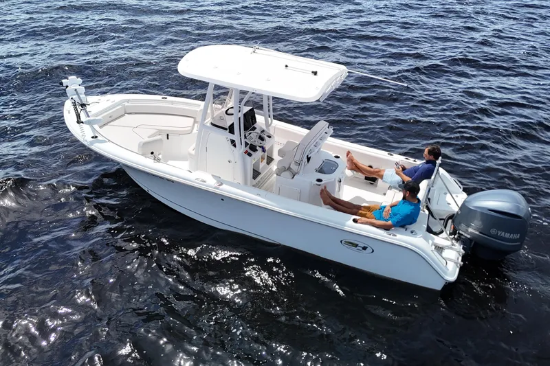 The Image of 2021 Sea Hunt Ultra 234 boat on water with two people relaxing onboard. - 0