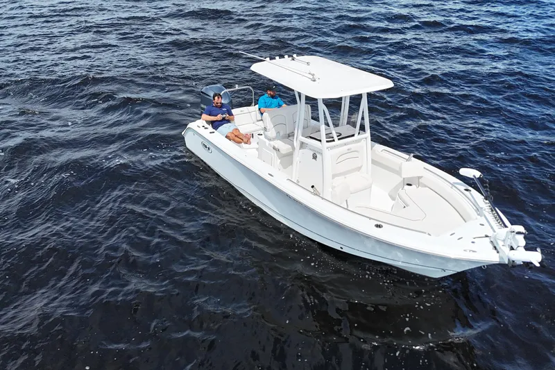 Slide: The Image of 2021 Sea Hunt Ultra 234 boat on open water with two passengers relaxing. - 11