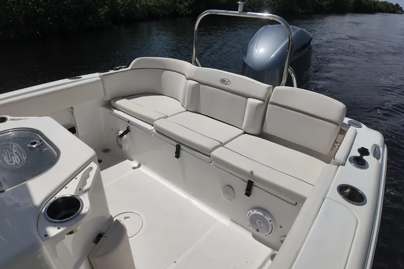 Slide: The Image of 2021 Sea Hunt Ultra 234 boat interior with cushioned seating and storage compartments. - 14
