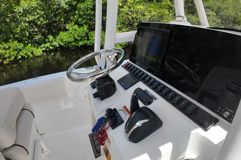 Slide: The Image of 2021 Sea Hunt Ultra 234 boat dashboard with steering wheel and control panel. - 19