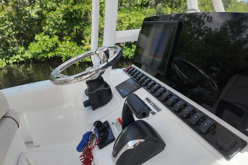 Slide: The Image of 2021 Sea Hunt Ultra 234 boat dashboard with steering wheel and control panel. - 20