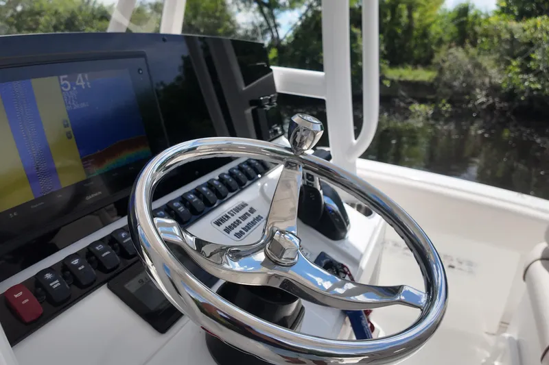 Slide: The Image of Steering wheel and controls of 2021 Sea Hunt Ultra 234 boat, featuring navigation display. - 21