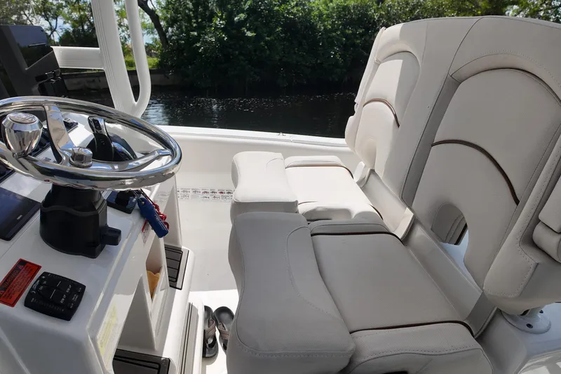 Slide: The Image of 2021 Sea Hunt Ultra 234 boat interior with steering wheel and cushioned seating. - 22