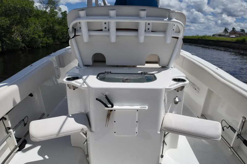 Slide: The Image of 2021 Sea Hunt Ultra 234 boat interior with fishing rod holders and seating. - 23