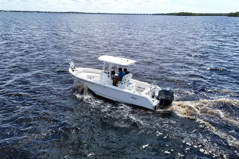 Slide: The Image of 2021 Sea Hunt Ultra 234 boat cruising on open water, featuring a Yamaha outboard motor. - 26