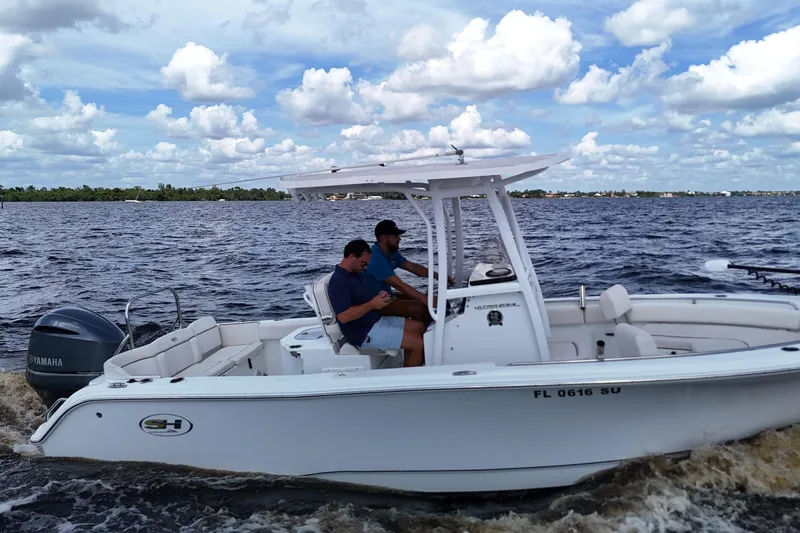 Slide: The Image of 2021 Sea Hunt Ultra 234 boat cruising on a sunny day with two people onboard. - 29