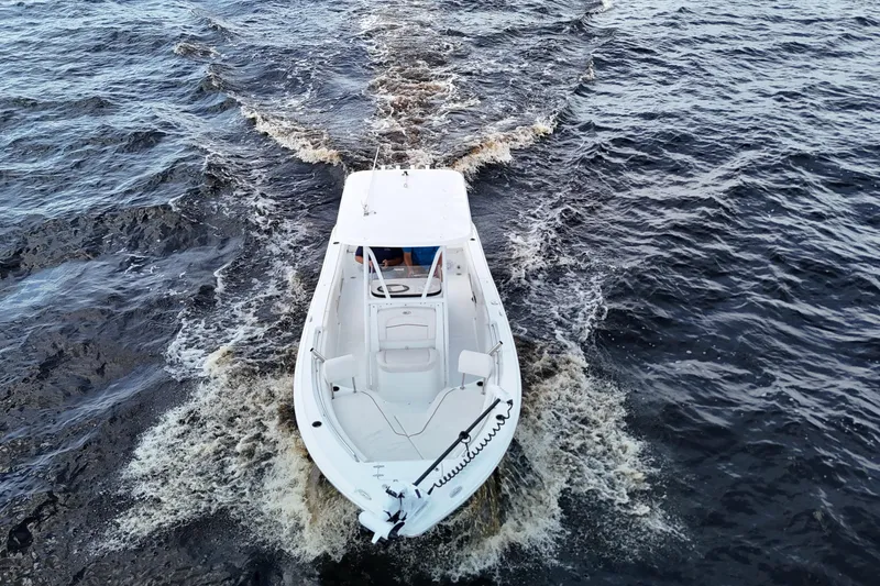 Slide: The Image of 2021 Sea Hunt Ultra 234 boat cruising on open water, aerial view. - 32