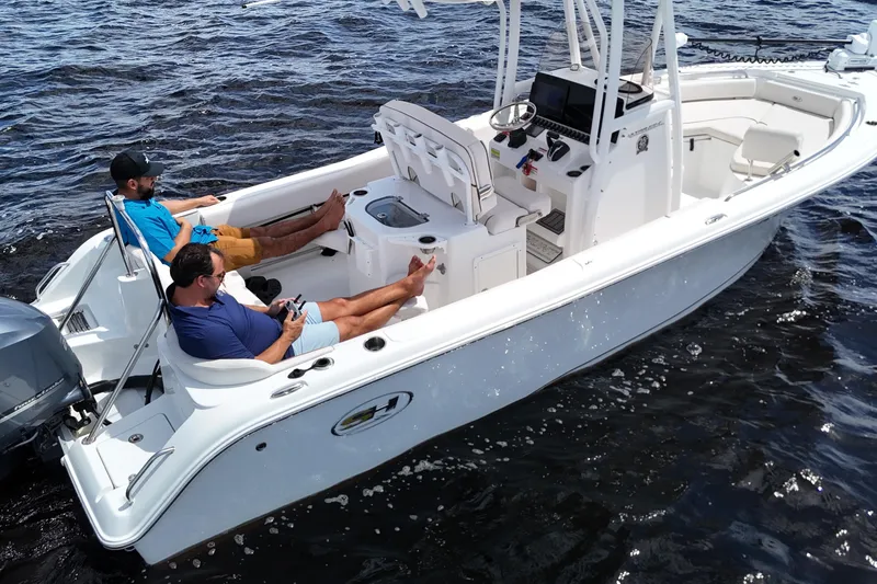 Slide: The Image of 2021 Sea Hunt Ultra 234 boat with two people relaxing on the water. - 38