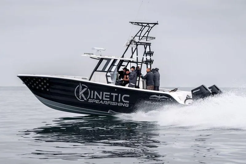 The Image of 2024 Invincible 33 Catamaran speeding on water, featuring "Kinetic Spearfishing" branding. - 0