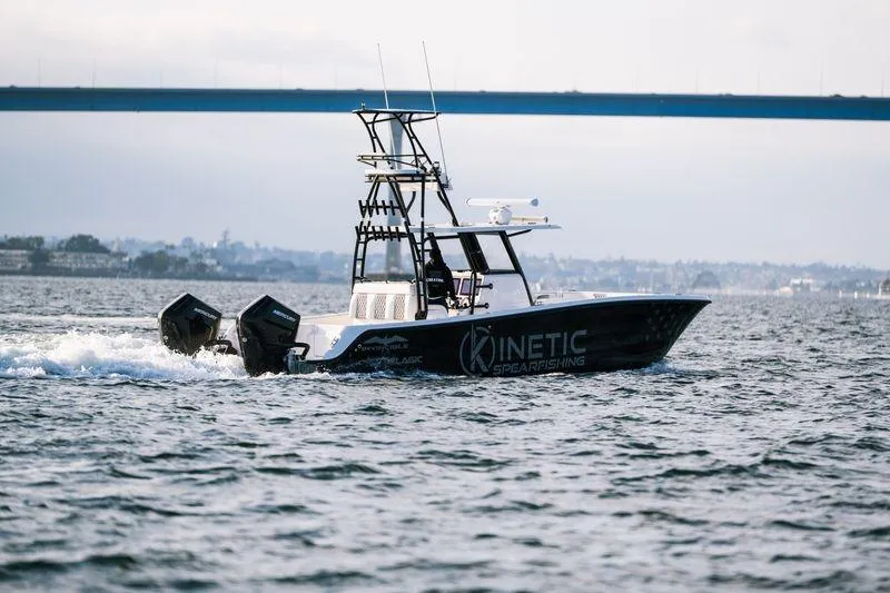 Slide: The Image of 2024 Invincible 33 Catamaran cruising on water under a bridge. - 6