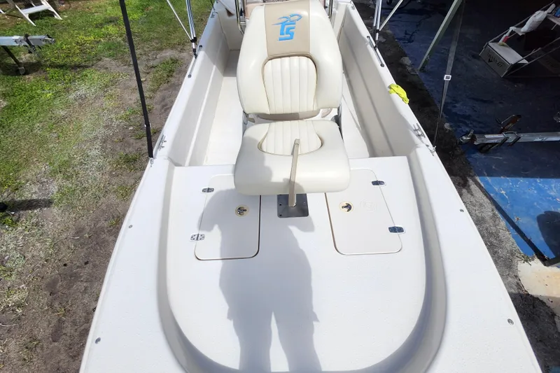 Slide: The Image of 2017 Carolina Skiff 1765 DLX boat interior with white seating and storage compartments. - 13